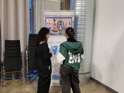 Zwei Jugendliche betrachten eine Ausstellungstafel